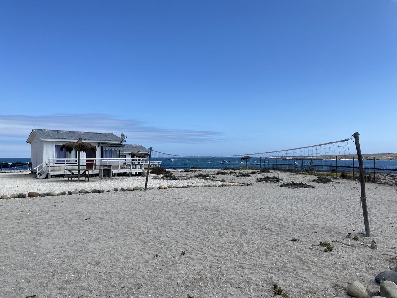 Cabaña del refugio en la playa, con una red de vóleibol