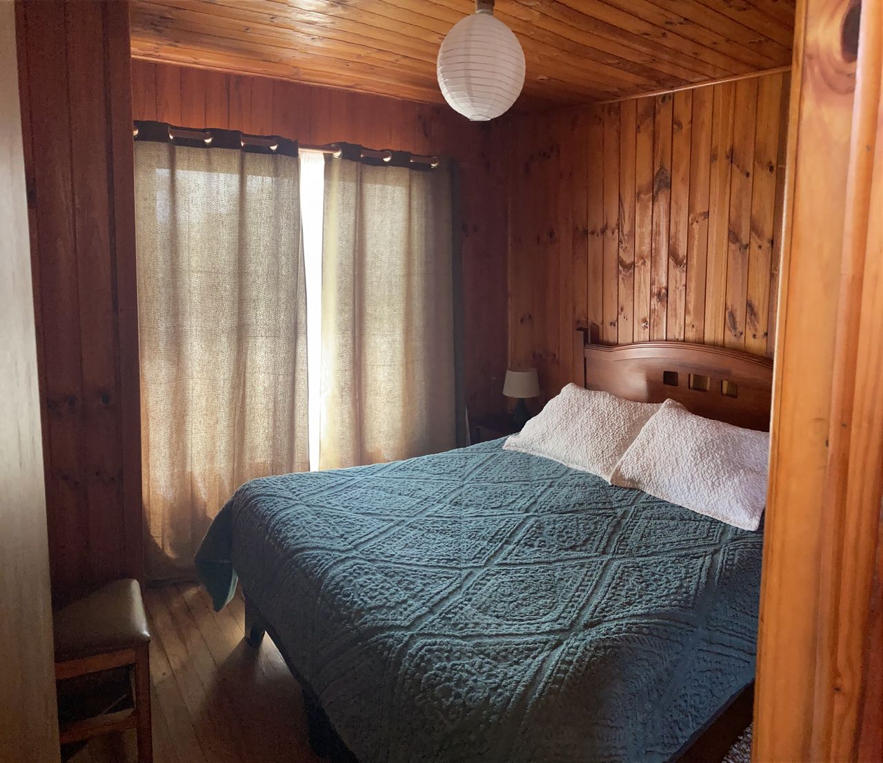 Dormitorio matrimonial con muros de madera